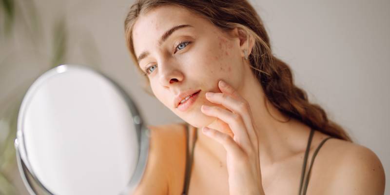 Woman checking skin in mirror