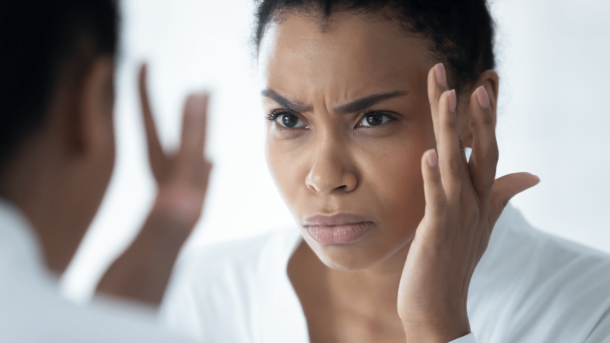 lady unhappy looking at mirror
